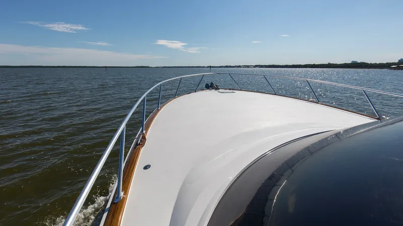 Slide: The Image of Bow View with Expansive Deck This image showcases the sleek bow of the 2024 Viking 54 Convertible, highlighting its expansive deck space and modern railings. The smooth, unobstructed surface provides ample room for sunbathing or enjoying panoramic sea views. The polished finish and s - 8439817