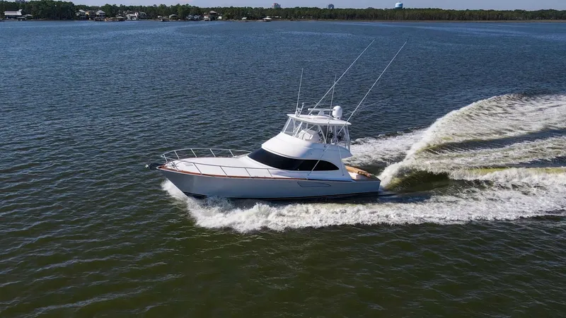 Slide: The Image of Aerial View of Viking 54 Convertible The 2024 Viking 54 Convertible, named 'Nomad', cuts through the water with impressive agility and style. The sleek hull design and powerful engine create a striking wake, showcasing the vessel's superior performance. With its elegant lines and robust cons - 8439823