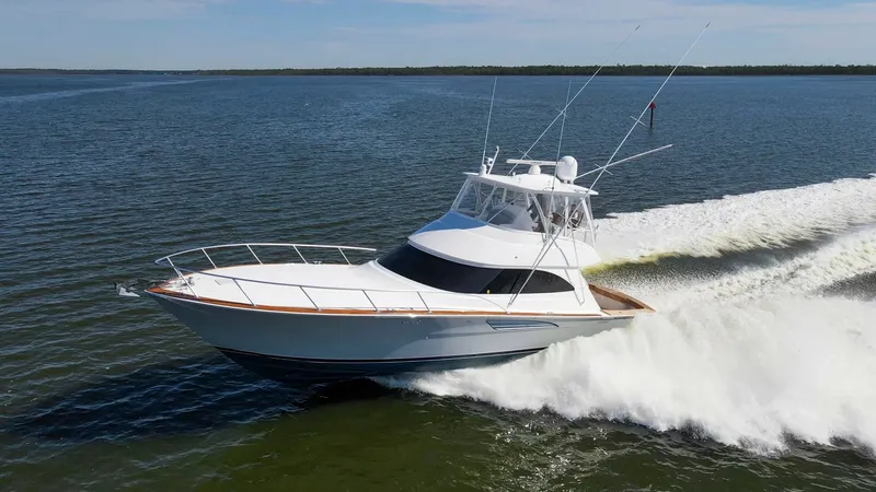 Slide: The Image of Viking 54 Convertible in Motion The 2024 Viking 54 Convertible 'Nomad' is captured gracefully slicing through the water, showcasing its sleek hull design and powerful performance. The spacious flybridge with its streamlined profile offers commanding views, while the polished teak accent - 8439830