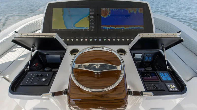 Slide: The Image of Flybridge Helm Station with Electronics The helm station of the 2024 Viking 54 Convertible 'Nomad' showcases a sleek and modern design, featuring dual multifunction displays for navigation and sonar. The polished wooden steering wheel adds a touch of elegance, while the well-organized control p - 8439795