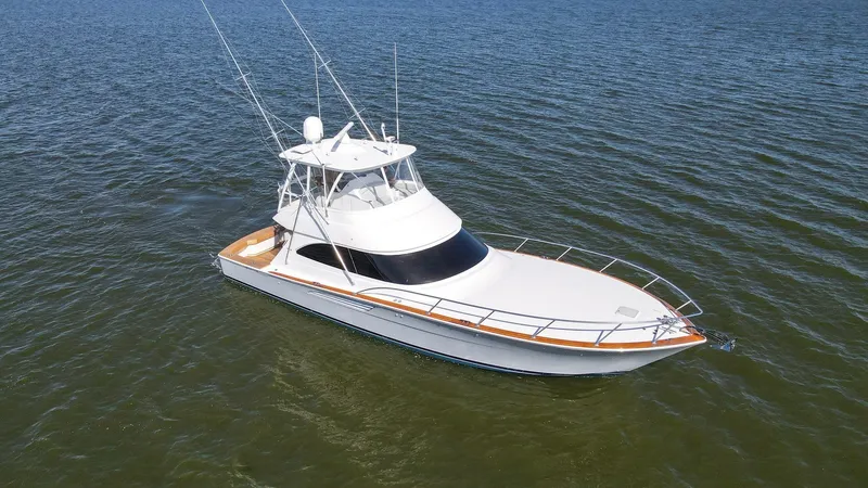 Slide: The Image of Aerial View of Forward Deck This aerial shot of the 2024 Viking 54 Convertible, 'Nomad', highlights the sleek and spacious forward deck. The elegant lines and sturdy railings provide a sense of security and style, while the expansive bow offers ample space for sunbathing or relaxati - 8439837