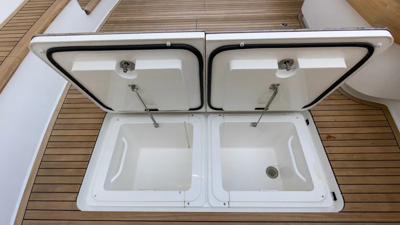 Slide: The Image of Cockpit Storage Compartments The Nomad's cockpit features dual storage compartments seamlessly integrated into the teak decking, ideal for keeping gear organized and accessible. These compartments are equipped with secure latches and durable hydraulic struts for easy opening and clos - 8439808