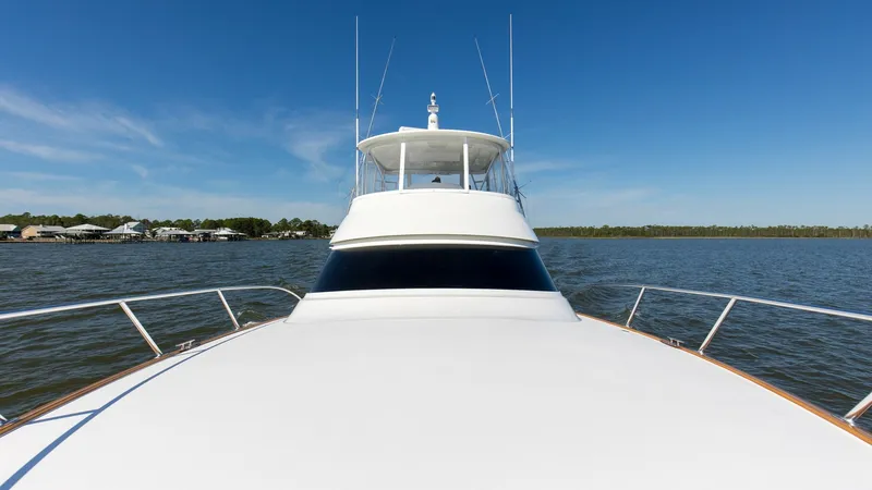 Slide: The Image of Bow View with Flybridge This image showcases the sleek bow of the 2024 Viking 54 Convertible, highlighting its streamlined design and expansive deck space. The flybridge above offers panoramic visibility and is equipped with advanced navigational equipment. The clean lines and m - 8439815