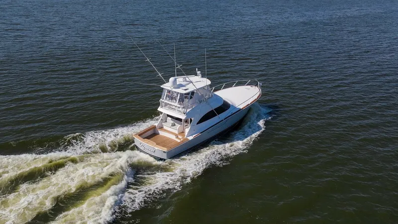 Slide: The Image of Aerial View of Flybridge and Cockpit The 2024 Viking 54 Convertible, Nomad, showcases its sleek design as it cuts through the water. The flybridge offers a commanding view with advanced navigation equipment, while the spacious cockpit is perfect for fishing or entertaining. The vessel's eleg - 8439824
