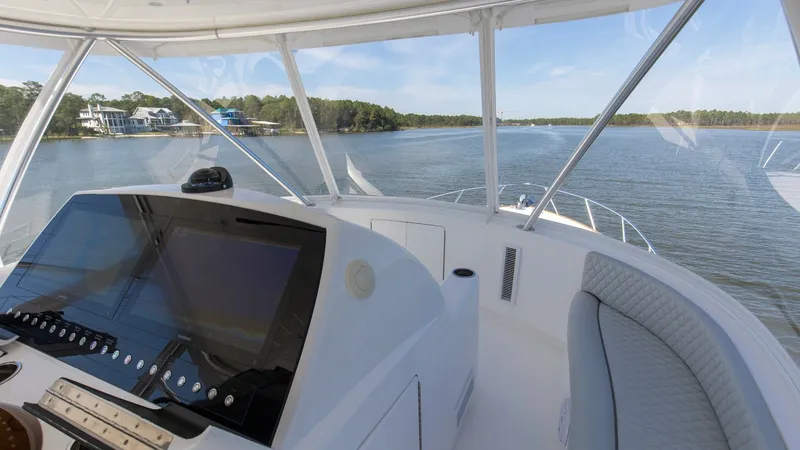 Slide: The Image of Flybridge Helm Station The flybridge of the 2024 Viking 54 Convertible features a sleek helm station with state-of-the-art navigation technology. The expansive windows offer panoramic views, enhancing the open-water experience. Plush seating surrounds the area, providing comfor - 8439800