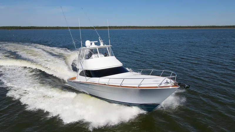 Slide: The Image of Bow View on Open Water The 2024 Viking 54 Convertible, Nomad, showcases a sleek and powerful bow slicing through open water. The vessel's advanced hull design and polished teak accents provide a perfect blend of performance and elegance. With its sturdy railings and expansive d - 8439834