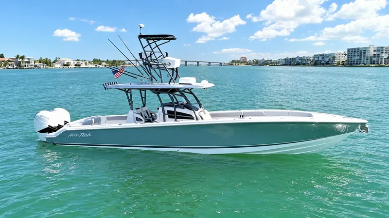 Slide: The Image of Side Profile of Nor-Tech 390 Sport This image showcases the sleek side profile of the 2020 Nor-Tech 390 Sport, featuring a streamlined hull and elegant design. The vessel is equipped with powerful outboard engines, ensuring impressive performance and speed on the water. The T-top provides - 8521469