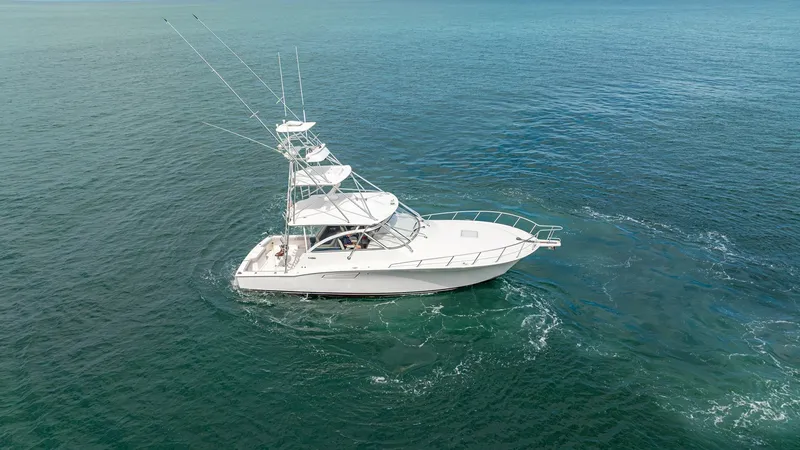 Slide: The Image of Aerial View of Cabo 40 Express This aerial shot captures the sleek design of the 2020 Cabo 40 Express, 'Knot Working'. The vessel's white hull glides gracefully through the water, showcasing its robust structure and elegant lines. The open deck and commanding tower are perfectly suited - 8511609
