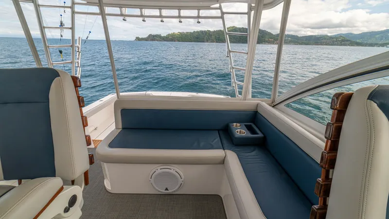 Slide: The Image of Aft Deck Seating Area The aft deck of the Cabo 40 Express features a comfortable seating area with plush, blue-upholstered cushions, perfect for relaxing while enjoying the view. The built-in cup holders add convenience, while the open design offers an unobstructed vista of th - 8511599