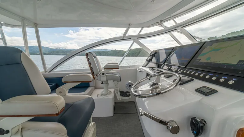 Slide: The Image of Helm Station with Dual Seating The helm station of the Cabo 40 Express features dual captain's chairs with plush cushioning for optimal comfort. Equipped with state-of-the-art navigation systems and a sleek steering wheel, the helm offers excellent visibility through expansive windows. - 8511597