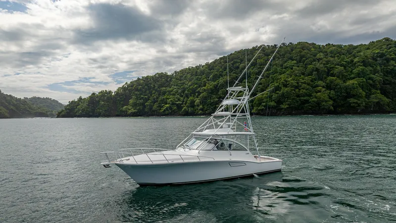 Slide: The Image of Profile View of Cabo 40 Express The 2020 Cabo 40 Express, 'Knot Working,' is shown in a serene coastal setting. Its sleek profile highlights the robust sportfishing tower, designed for optimal visibility and functionality. The streamlined hull and spacious deck make it ideal for both se - 8511604