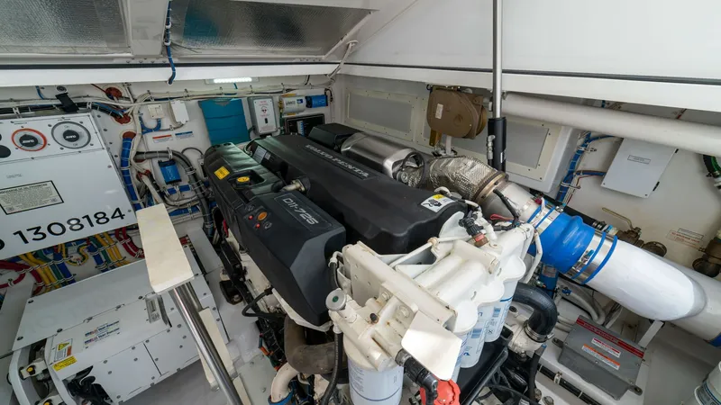 Slide: The Image of Engine Room with Twin Engines This image showcases the meticulously organized engine room of the 2020 Cabo 40 Express, featuring powerful twin engines. The space is efficiently laid out, ensuring easy access for maintenance and operation. Sophisticated systems and clean installations - 8511602