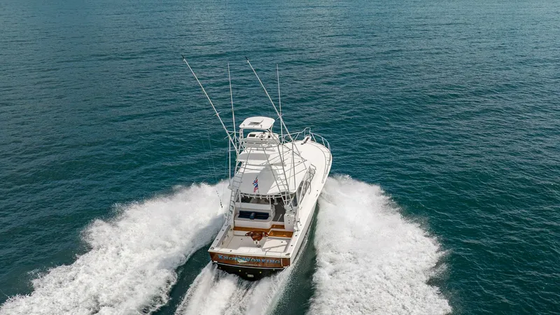 Slide: The Image of Aerial View of Cockpit and Tower This dynamic aerial shot showcases the Cabo 40 Express, highlighting its spacious cockpit and sturdy tower. The vessel cuts through the water with ease, demonstrating its powerful performance and sleek design. The open deck area is ideal for fishing or le - 8511617