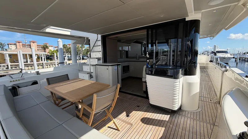 Slide: The Image of Spacious Aft Deck with Dining Area This inviting aft deck on the 2026 Absolute Navetta 58 features a sleek teak flooring and a comfortable dining area, perfect for alfresco meals. The space is complemented by a stylish built-in seating arrangement and a practical wooden dining table. The s - 8640141