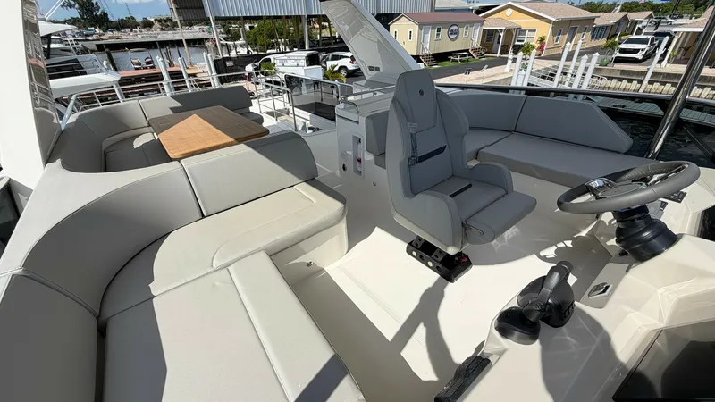 Slide: The Image of Flybridge Helm and Seating Area The flybridge of the 2026 Absolute Navetta 58 features a spacious helm station with a modern captain's chair and ergonomic controls. Surrounding the helm, a plush seating area offers ample space for relaxation, complemented by a sleek wooden table ideal f - 8640145