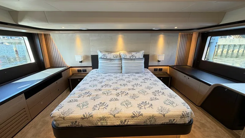 Slide: The Image of Master Stateroom with Panoramic Views The master stateroom of the 2026 Absolute Navetta 58 exudes luxury and comfort, featuring a spacious king-size bed with elegant bedding. Large windows envelop the room, offering breathtaking panoramic views and ample natural light. The modern design is co - 8640129