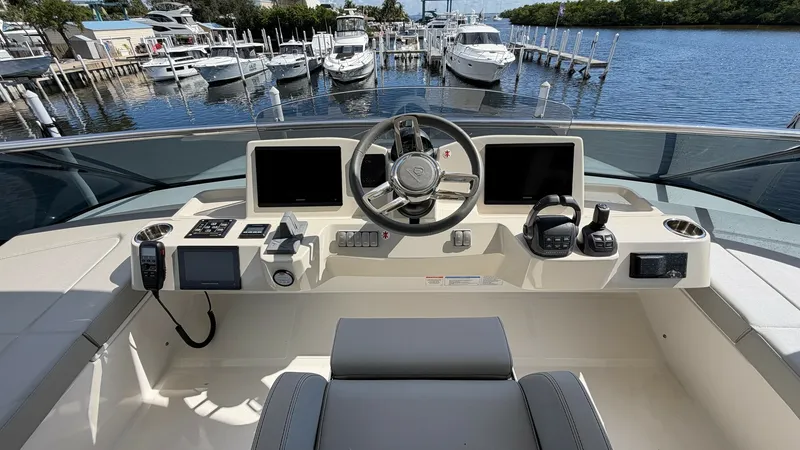 Slide: The Image of Flybridge Helm Station The flybridge helm station of the Absolute Navetta 58 features a modern and ergonomic design, equipped with advanced navigation systems and dual touch-screen displays. The leather-wrapped steering wheel and comfortable seating ensure effortless maneuverab - 8640144