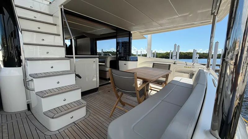 Slide: The Image of Spacious Aft Deck with Seating Area The aft deck of the 2026 Absolute Navetta 58 offers a welcoming outdoor space with a stylish teak deck. Featuring a comfortable L-shaped bench and a sleek wooden table, it's perfect for al fresco dining or relaxing with a view. The elegant staircase leads - 8640142