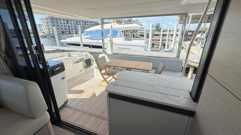 Slide: The Image of Aft Deck with Dining Area The aft deck of the 2026 Absolute Navetta 58 features a stylish dining area, ideal for al fresco meals. A sleek wooden table and comfortable chairs are set against a beautifully crafted teak deck, offering a perfect blend of elegance and functionality. Th - 8640139