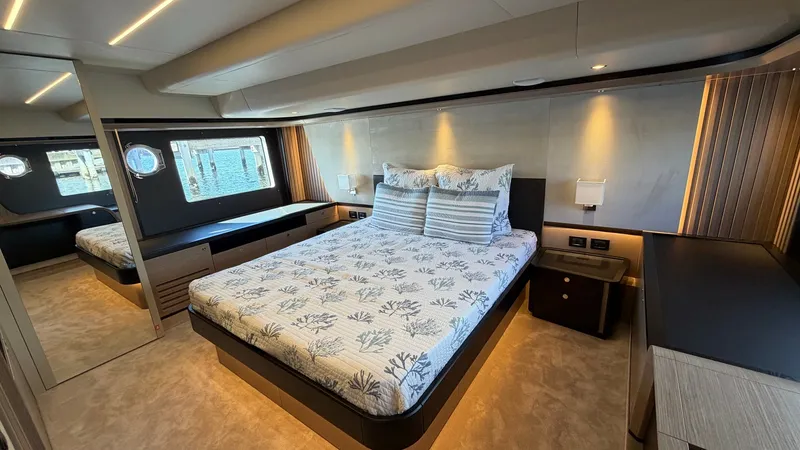 Slide: The Image of Master Stateroom with Modern Design The master stateroom aboard the Absolute Navetta 58 features a spacious layout with elegant finishes. A large, plush bed is the centerpiece, surrounded by sleek built-in cabinetry and ambient lighting that enhances the room's warmth. Expansive windows off - 8640132