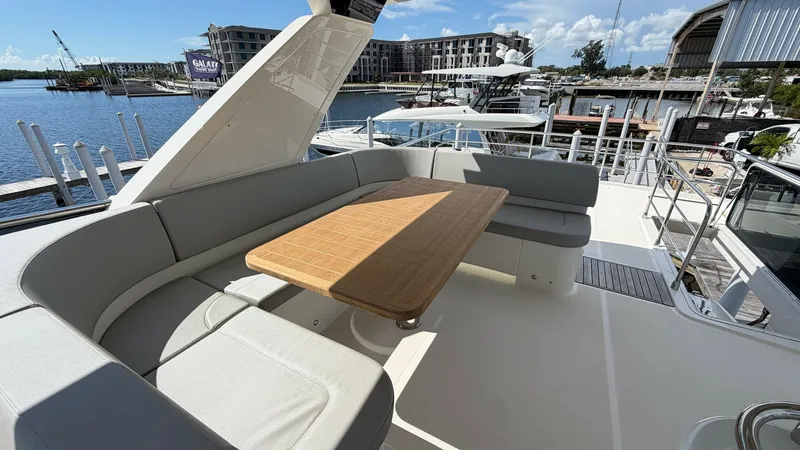 Slide: The Image of Flybridge Seating Area with Table The flybridge of the 2026 Absolute Navetta 58 offers a spacious seating area, perfect for entertaining or enjoying a meal al fresco. The elegant wooden table is surrounded by plush, wrap-around seating, providing comfort and style. This open-air space is - 8640146