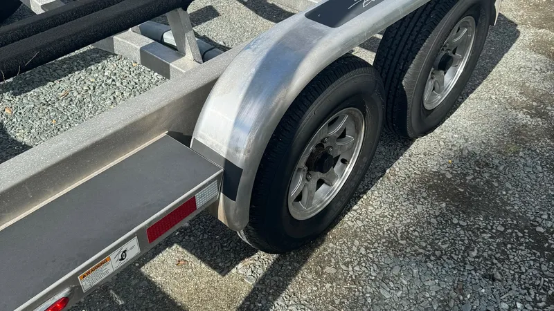 Slide: The Image of Galati Yacht Sales Trailer Wheels This image showcases the robust trailer wheels of the Galati Yacht Sales Trade vessel. The dual-axle setup ensures stability and durability for transporting the 2023 SeaVee 270Z. The polished aluminum fenders add a sleek, modern touch, complementing the s - 8398135