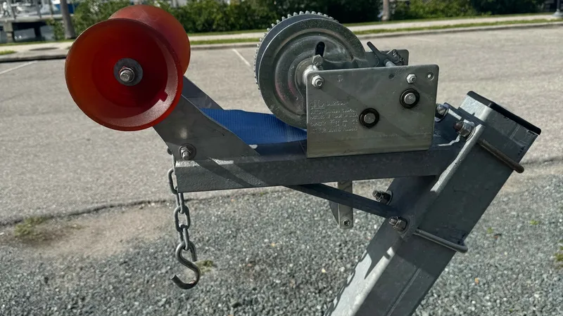 Slide: The Image of Trailer Winch and Roller Assembly This image showcases the trailer winch and roller assembly, essential for securing and guiding the SeaVee 270Z onto the trailer. The sturdy metal construction ensures durability, while the bright red roller provides smooth operation and protection for the - 8398136