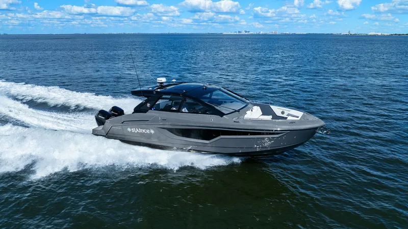Slide: The Image of Cruisers Yachts 42 GLS Side View The 2023 Cruisers Yachts 42 GLS showcases its sleek and modern design as it glides effortlessly across the water. The vessel's aerodynamic profile and stylish dark hull are complemented by large windows, offering panoramic views and natural light to the i - 8619175