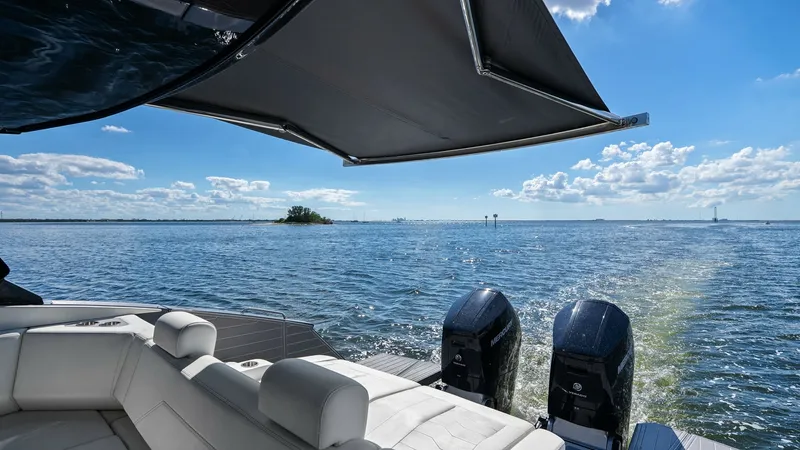 Slide: The Image of Aft Deck with Twin Outboards The aft deck of the 2023 SALINTE 42 GLS by Cruisers Yachts showcases luxurious seating with plush white cushions, perfect for relaxation. Overhead, a sleek retractable sunshade provides ample cover, enhancing comfort under the sun. The twin outboard engin - 8619159