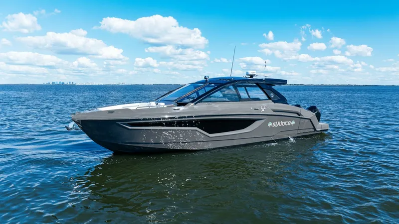Slide: The Image of Side Profile of 2023 Cruisers Yachts 42 GLS The 2023 Cruisers Yachts 42 GLS showcases a sleek, modern design with a striking dark hull and expansive windows. The vessel's aerodynamic profile is complemented by a spacious deck, ideal for both leisure and performance. This model combines luxury and i - 8619183