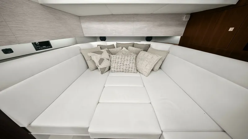 Slide: The Image of Luxurious Forward Cabin Lounge Area The 2023 Cruisers Yachts 42 GLS features a spacious forward cabin lounge, designed for ultimate comfort and relaxation. The plush, white seating is complemented by a selection of decorative pillows, creating an inviting space for unwinding. Modern finishe - 8619152