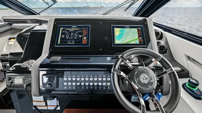 Slide: The Image of Helm Station with Advanced Navigation Displays The helm station of the 2023 Cruisers Yachts 42 GLS features cutting-edge navigation technology, including dual multifunction displays for seamless control. The sleek steering wheel complements the modern design, while the dashboard offers intuitive acces - 8619125