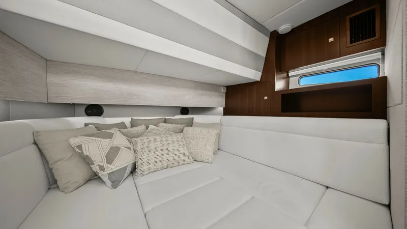 Slide: The Image of Spacious Forward Cabin Lounge Area The forward cabin of the 2023 Cruisers Yachts 42 GLS offers a luxurious and comfortable lounging space. Featuring plush, white upholstery, this area is complemented by stylish accent pillows, providing a relaxing environment. The cabin is enhanced by natu - 8619153