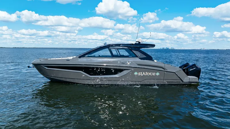 Slide: The Image of Side Profile of 2023 Cruisers Yachts 42 GLS This image showcases the sleek side profile of the 2023 Cruisers Yachts 42 GLS, named SALINTE. The boat's modern design is highlighted by its streamlined hull and sophisticated dark gray finish. Equipped with powerful outboard engines, this vessel promise - 8619169
