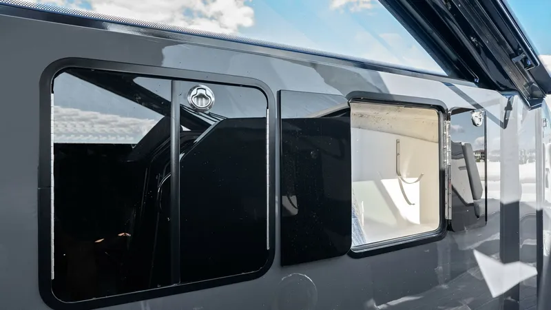 Slide: The Image of Starboard Hull Windows and Reflections This image showcases the sleek design of the 2023 Cruisers Yachts 42 GLS, highlighting the starboard hull windows. The glossy finish and contemporary styling are accentuated by reflective surfaces, creating a modern and elegant appearance. The windows off - 8619148
