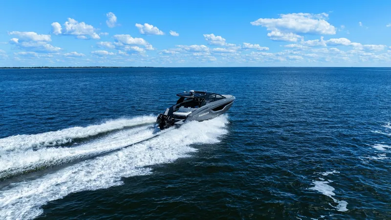 Slide: The Image of Aerial View of Cruising Yacht The 2023 Cruisers Yachts 42 GLS cuts through the open water with elegance and power. This sleek vessel showcases a modern design, highlighted by its sharp lines and dynamic performance. The expansive open sea and clear blue sky create a breathtaking backd - 8619172