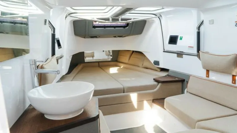 Slide: The Image of Spacious Interior Cabin with Seating The interior cabin of the 2022 Axopar 37 Barbus offers a modern and inviting space with plush seating and a convertible berth. Natural light floods through overhead skylights, enhancing the bright and airy atmosphere. A sleek basin adds a touch of luxury, - 8439358