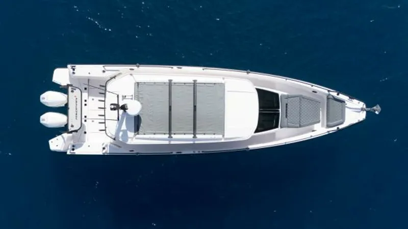 Slide: The Image of Aerial View of Axopar 37 Deck This top-down view showcases the sleek design of the 2022 Axopar 37 Barbus. The vessel features a spacious deck layout with ample seating and sunbathing areas, perfect for leisure cruising. The triple outboard engines promise powerful performance, ideal f - 8439359