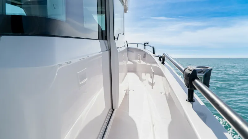 Slide: The Image of Starboard Side Walkway View This image showcases the sleek starboard side walkway of the 2022 Axopar 37 Barbus. The clean, modern lines and sturdy handrails provide both style and safety as you move along the vessel. The expansive ocean views and bright, sunlit finish enhance the al - 8439363