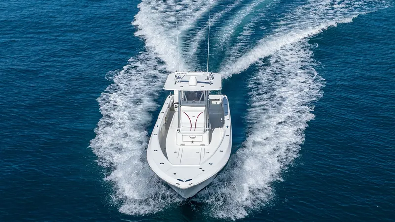 Slide: The Image of Aerial View of Bow in Motion The 2013 SeaVee 32, 'Poco Mas', cuts through the water with precision, showcasing its sleek bow design. The vessel's robust hull and spacious deck are visible, providing an ideal setup for both fishing and leisure. The clean lines and powerful wake highli - 8738117