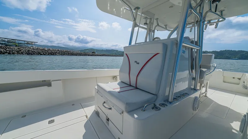 Slide: The Image of Center Console Seating Area This image showcases the comfortable and functional center console seating area of the 2013 SeaVee 32 model, Poco Mas. The clean, white upholstery with red accents adds a touch of elegance, while the ample storage compartments enhance practicality. The st - 8738103