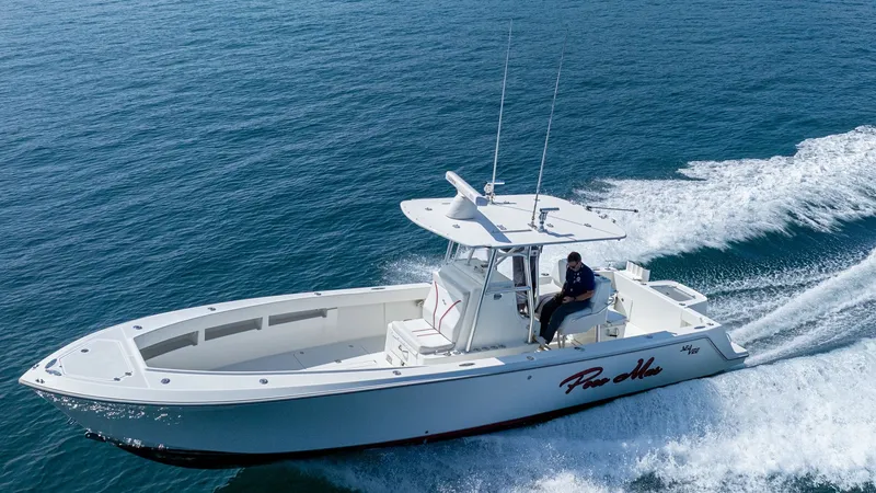 Slide: The Image of Aerial View of SeaVee 32 Cockpit This image captures the sleek and spacious cockpit of the 2013 SeaVee 32, 'Poco Mas'. The open deck layout provides ample space for movement, ideal for both leisure and fishing activities. The T-top offers shade and protection, enhancing comfort during ex - 8738113