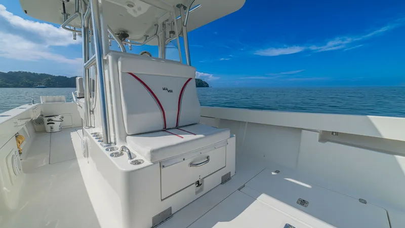Slide: The Image of Center Console Seating Area This image showcases the central seating area of the 2013 SeaVee 32, featuring a comfortable bench with stylish red accents. The seating is complemented by practical under-seat storage, perfect for keeping essentials close at hand. The area is surrounded - 8738100
