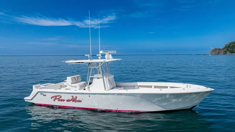 Slide: The Image of Side Profile of SeaVee 32 This image showcases the sleek side profile of the 2013 SeaVee 32, 'Poco Mas.' The vessel features a streamlined hull design, accented by a modern T-top and dual antennas for improved communication. The open deck layout offers ample space for fishing and - 8738108