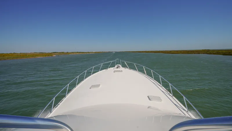 Slide: The Image of Expansive Bow View at Sea The sleek bow of the 2001 Hatteras 60 Convertible, Uno Mas, cuts through the water with precision. Featuring sturdy stainless steel railings and ample deck space, this vessel ensures safety and comfort on open waters. The clear, unobstructed view ahead pr - 8734354