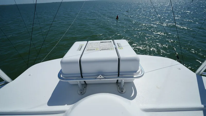 Slide: The Image of Flybridge Bow with Life Raft Storage This image showcases the flybridge bow of the 2001 Hatteras 60 Convertible 'Uno Mas', featuring a neatly secured life raft storage. The clean, white finish enhances the sleek and functional design of the vessel's upper deck. Expansive ocean views provide - 8734369