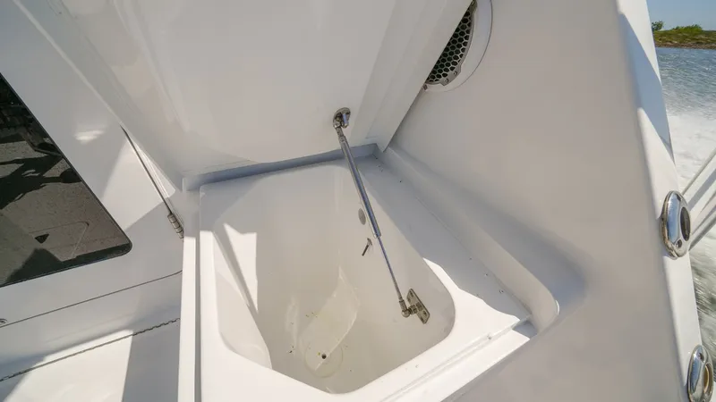 Slide: The Image of Cockpit Fish Box with Lid This image showcases the spacious fish box located in the cockpit of the 2001 Hatteras 60 Convertible. The box features a sturdy lid and ample storage space, ideal for keeping your catch fresh during long fishing trips. Its sleek, white finish complements - 8734350