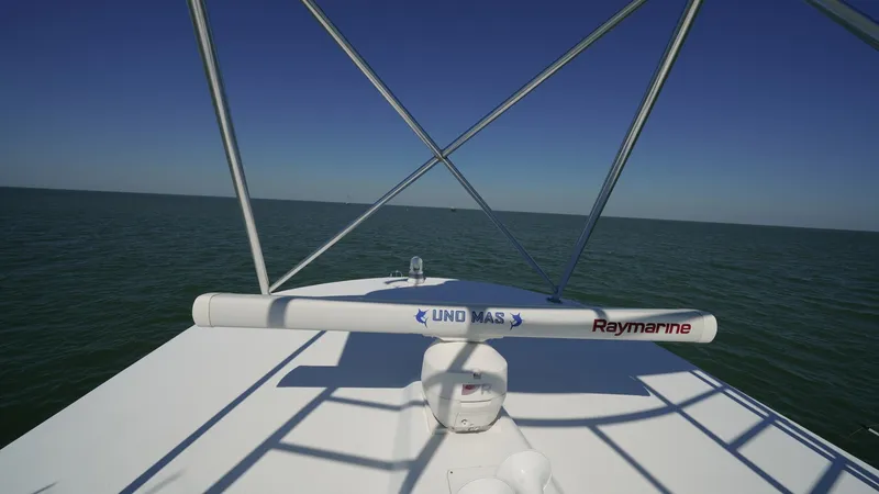 Slide: The Image of Flybridge with Radar Array View This image showcases the flybridge of the 2001 Hatteras 60 Convertible, featuring a prominent Raymarine radar array. The sleek design and open visibility offer an impressive vantage point for navigation. The clear, unobstructed view emphasizes the vessel' - 8734370