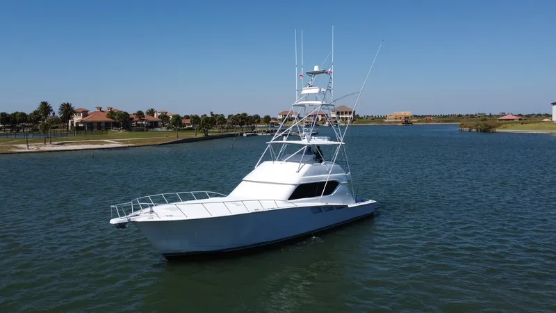 Slide: The Image of Exterior View of Hatteras 60 Convertible The 2001 Hatteras 60 Convertible 'Uno Mas' showcases its sleek and robust exterior design, perfect for both cruising and sportfishing. The yacht features a prominent flybridge with a substantial tower, ideal for navigation and spotting fish. Its clean lin - 8734372