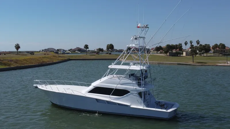 Slide: The Image of Side Profile with Tower and Cockpit This image showcases the sleek side profile of the 2001 Hatteras 60 Convertible, 'Uno Mas'. The vessel features a prominent tower for an elevated view, ideal for spotting fish. The spacious cockpit offers ample space for angling activities, while the clea - 8734375